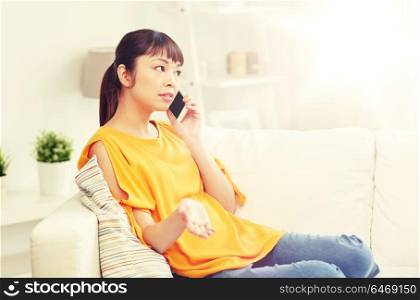 people, technology, communication and problem concept - young asian woman calling on smartphone at home. young asian woman calling on smartphone at home