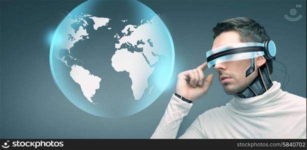 people, technology, future and progress - man with futuristic 3d glasses and microchip implant or sensors over blue background and earth globe hologram