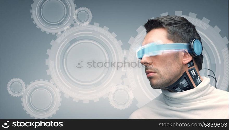 people, technology, future and progress - man with futuristic glasses and microchip implant or sensors over gray background with cogwheel mechanism projection