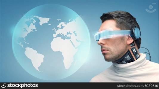 people, technology, future and progress - man with futuristic glasses and microchip implant or sensors over blue background and earth globe hologram