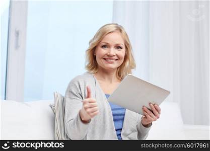 people, technology, gesture and internet concept - happy middle aged woman with tablet pc computer showing thumbs up at home