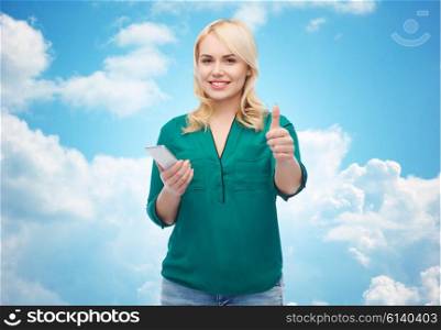 people, technology, gesture, communication and leisure concept - happy young woman with smartphone texting message over blue sky and clouds background