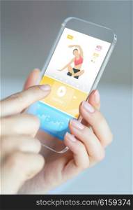 people, technology, sport and fitness concept - close up of female hand with smartphone with sports application on screen