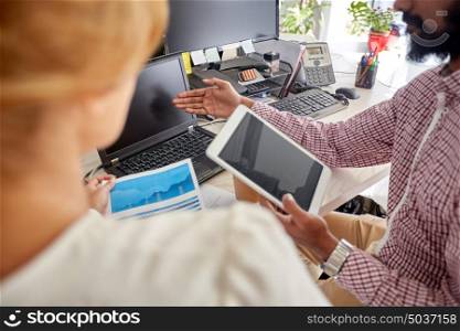 people, technology, statistics and corporate concept - business team with laptop, chart and tablet pc computer at office. business team with laptop, chart and tablet pc