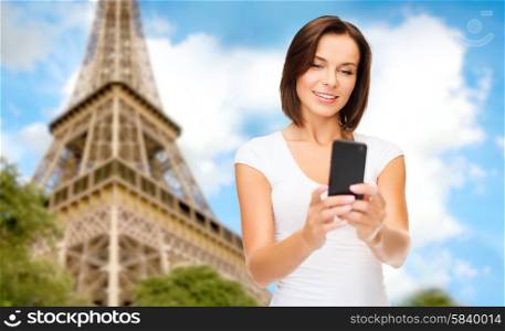 people, technology, tourism and travel concept - young woman taking selfie with smartphone over paris eiffel tower background