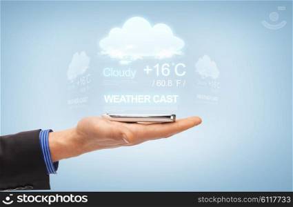 people, technology, weather cast and business concept - close up of male hand with smartphone and forecast projection