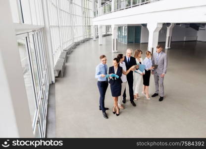 people, technology, work and corporate concept - business team with tablet pc computers and folders at office. business team with tablet pc and folders at office