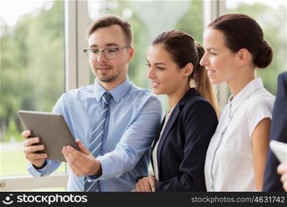 people, technology, work and corporate concept - business team with tablet pc computer at office