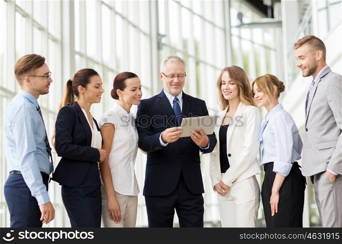 people, technology, work and corporate concept - business team with tablet pc computer at office