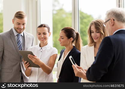 people, technology, work and corporate concept - business team with tablet pc computers at office