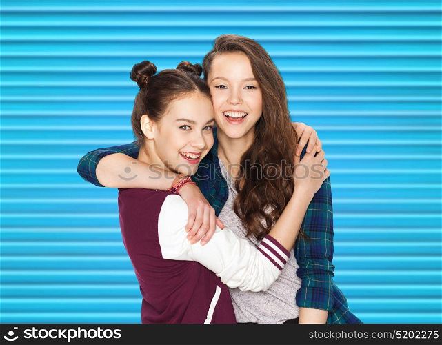 people, teens and friendship concept - happy smiling pretty teenage girls or friends hugging over blue ribbed background. happy smiling pretty teenage girls hugging