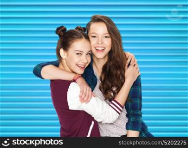 people, teens and friendship concept - happy smiling pretty teenage girls or friends hugging over blue ribbed background. happy smiling pretty teenage girls hugging
