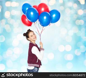 people, teens, holidays and party concept - happy smiling pretty teenage girl with helium balloons over blue holidays lights background
