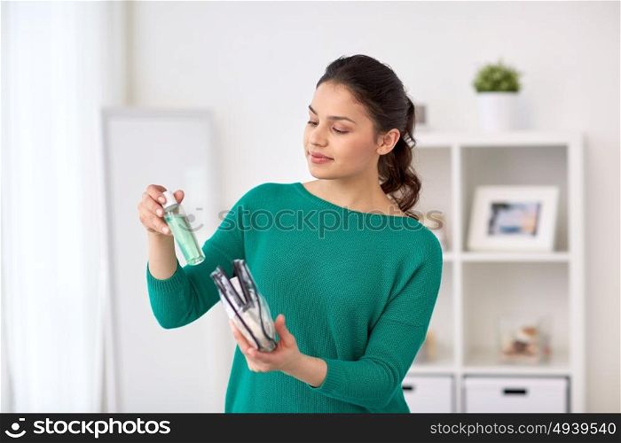 people, toiletry and concept - woman packing cosmetics to cosmetic bag at home. woman packing cosmetics to cosmetic bag at home