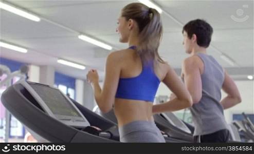 People training in fitness club, gym and sport activity. Young man and woman exercising and running on treadmill, athletes with wellness equipment. 1of27