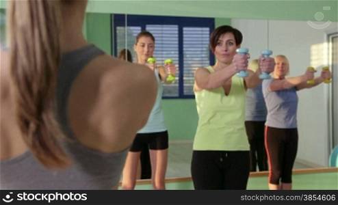 People training in fitness club, gym and sport activity. Group of women with instructor exercising with weights. 24of27