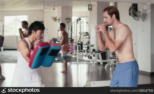 People training, working out, doing exercise in gym and fitness club, sport and martial arts for wellness and well-being. Personal trainer and student, man doing kickboxing for self-defense. 26of29