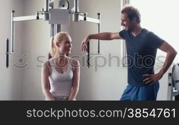 People training, working out, doing exercise in gym and fitness club, sport and bodybuilding for wellness and well-being. Man and woman talking and relaxing near equipment. 13of29