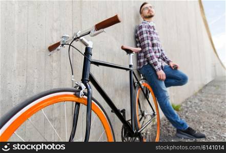 people, transport, leisure and lifestyle - close up of hipster fixed gear bike and man on city street