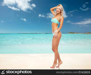 people, travel and tourism concept - happy smiling young woman in bikini swimsuit over exotic tropical beach background. happy woman in bikini swimsuit on summer beach
