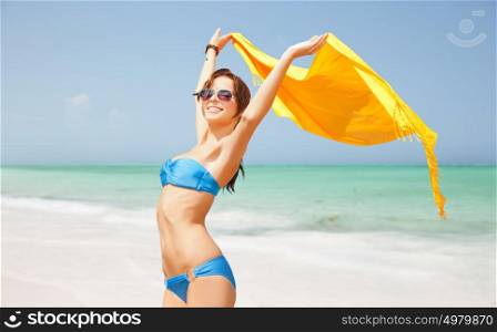 people, travel, summer holidays and vacation concept - beautiful woman in bikini and sunglasses with pareo over exotic tropical beach background. woman in bikini and sunglasses with pareo on beach
