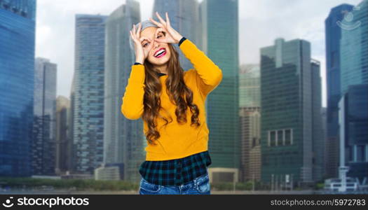 people, travel, tourism and fashion concept - happy young woman or teen girl in casual clothes and hipster hat having fun over city buildings background