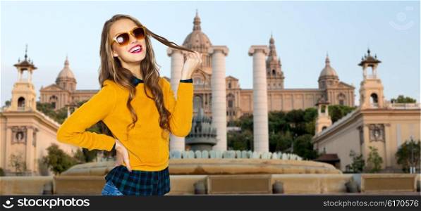 people, travel, tourism and fashion concept - happy young woman or teen girl in casual clothes and sunglasses over national museum of barcelona background