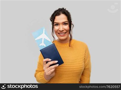 people, travel, tourism and vacation concept - portrait of happy smiling young woman with pierced nose with passport and air ticket over grey background. smiling young woman with passport and air ticket