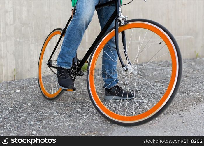 people, travel, tourism, transport and lifestyle - close up of young hipster man with fixed gear bike on city street