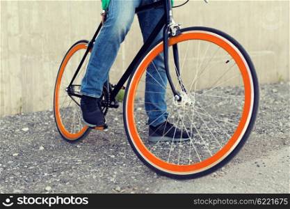 people, travel, tourism, transport and lifestyle - close up of young hipster man with fixed gear bike on city street