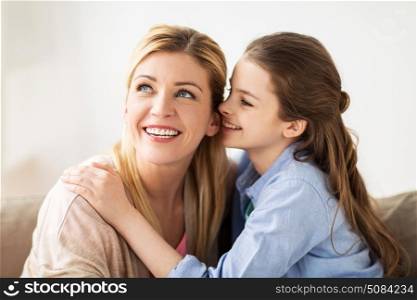 people, trust and family concept - happy daughter whispering secret to her mother at home. happy girl whispering secret to her mother at home. happy girl whispering secret to her mother at home