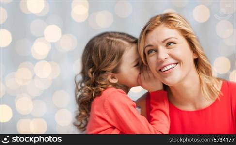 people, trust, love, family and motherhood concept - happy daughter whispering gossip to her mother over holiday lights background