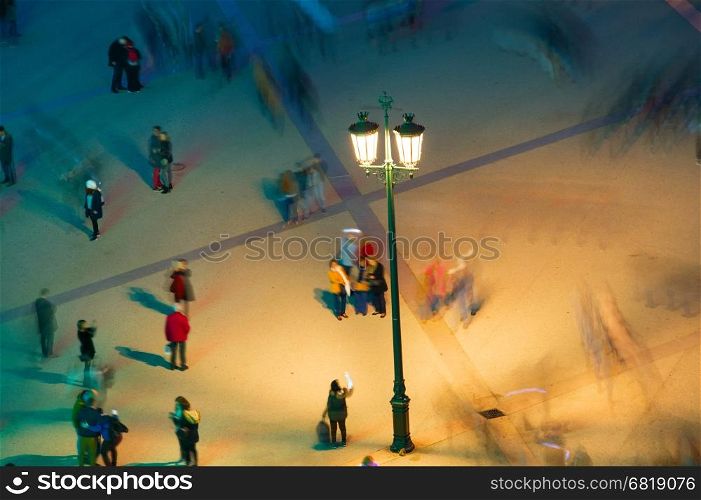 People under a lantern. Long exposure. Motion blur