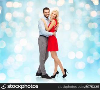 people, valentines day, love, couple and christmas concept - happy young woman and man hugging over blue holidays lights background