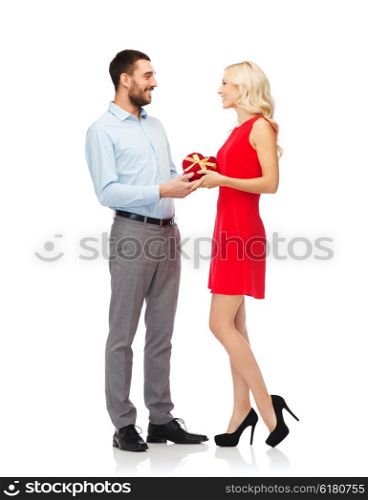 people, valentines day, love, couple and holidays concept - happy young man giving woman red heart shaped gift box