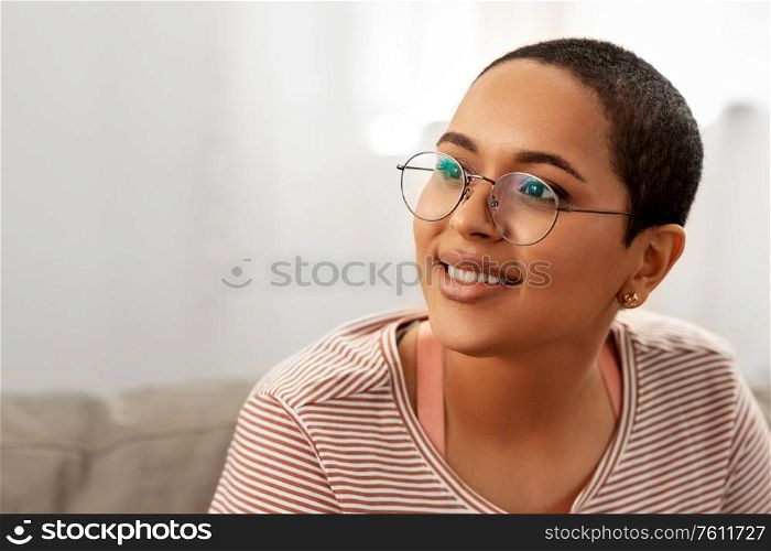people, vision and leisure concept - portrait of happy smiling african american woman in glasses at home. portrait of african american woman in glasses