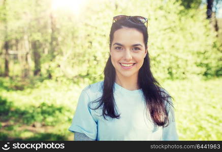 people, volunteering and environment concept - happy young volunteer woman outdoors. happy young volunteer woman outdoors