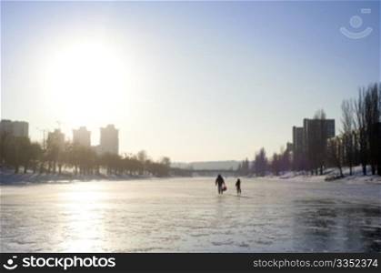 People walking by the Frozen river in the sunshine day