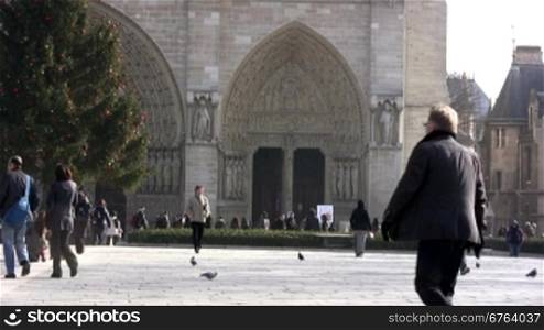 People walking in front of Notre Dame, Paris. Recognizable faces, please only editorial use.