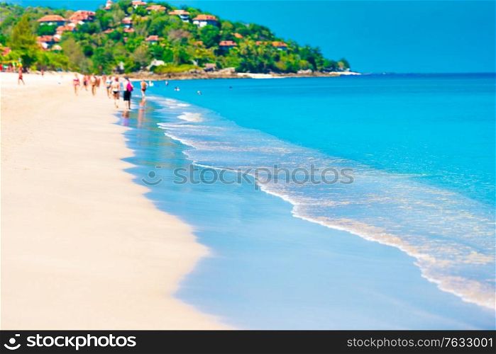 People walking near blue sea water on sand beach
