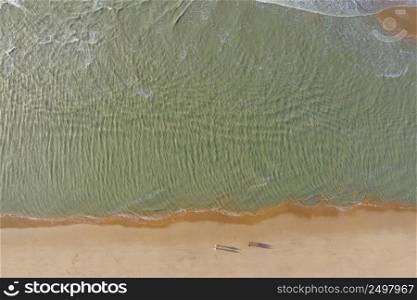 People walking on a north sea sandy beach, aerial drone view