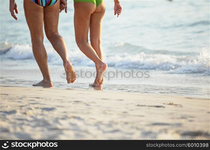 People walking on beach. Close-up of people legs walking on beach