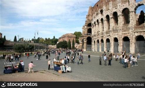 People walking outside the Coliseum in a sunny day.