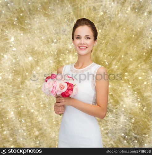 people, wedding, holidays and celebration concept - smiling bride or bridesmaid in white dress with bouquet of flowers over yellow lights background