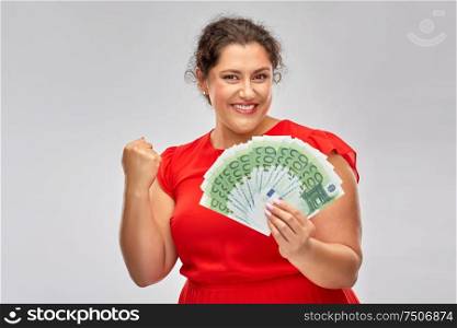 people, winning and finances concept - happy woman in red dress holding hundreds of euro money banknotes celebrating success over grey background. happy woman holding hundreds of money banknotes