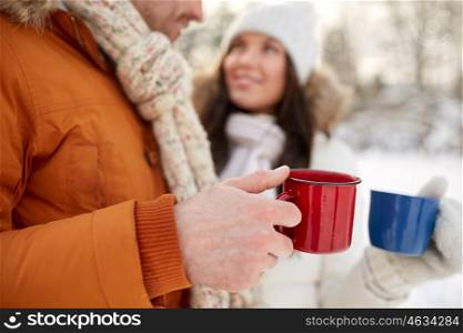 people, winter, drinks and season concept - close up of happy couple holding hot tea cups