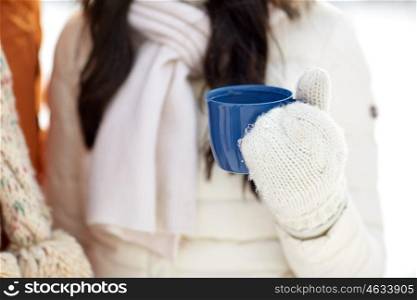 people, winter, drinks and season concept - close up of woman holding hot tea cup