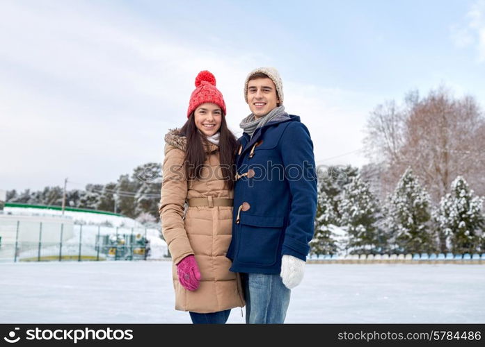 people, winter, friendship, love and leisure concept - happy couple ice skating on rink outdoors