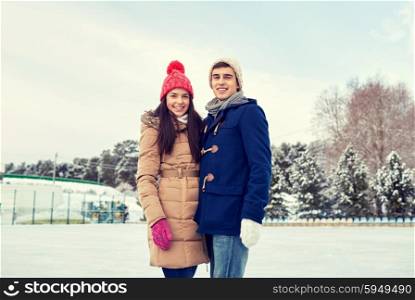 people, winter, friendship, love and leisure concept - happy couple ice skating on rink outdoors