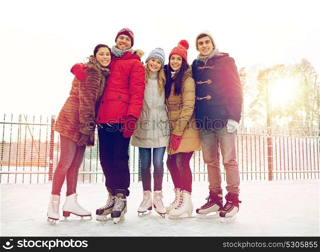 people, winter, friendship, sport and leisure concept - happy friends ice skating and hugging on rink outdoors. happy friends ice skating on rink outdoors